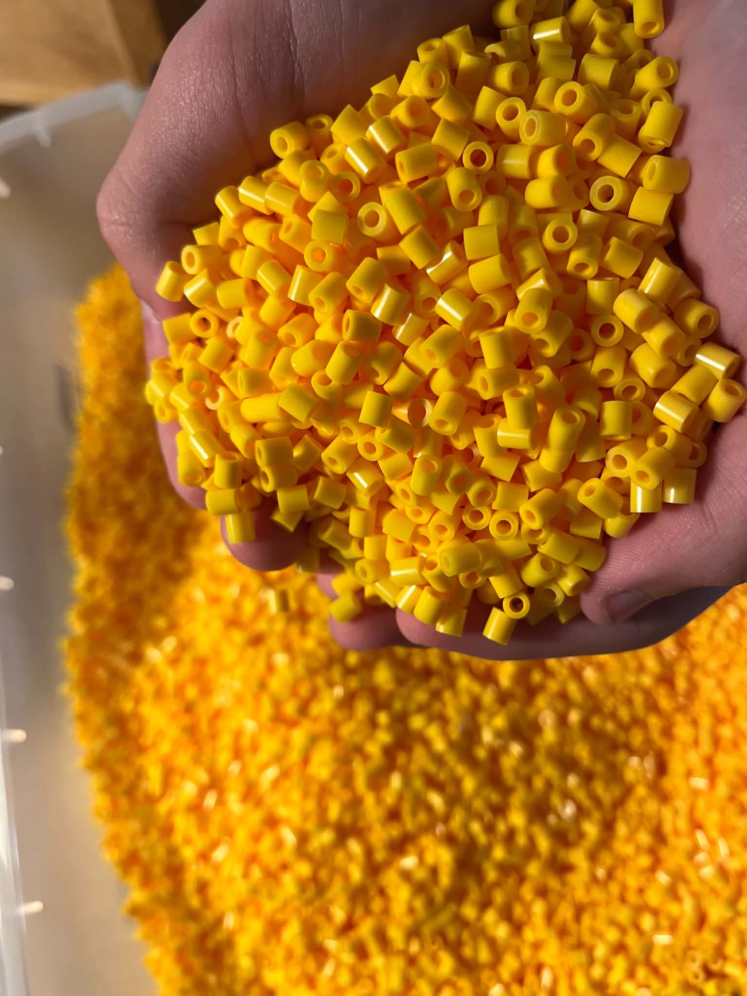 Hænder fulde af gule perler